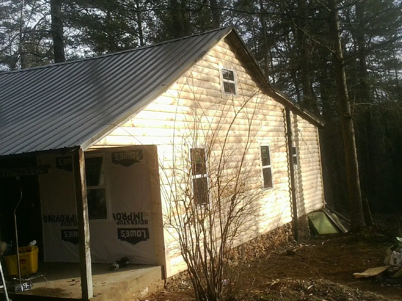 Log siding gable end under a dark metal roof edge in Grand View