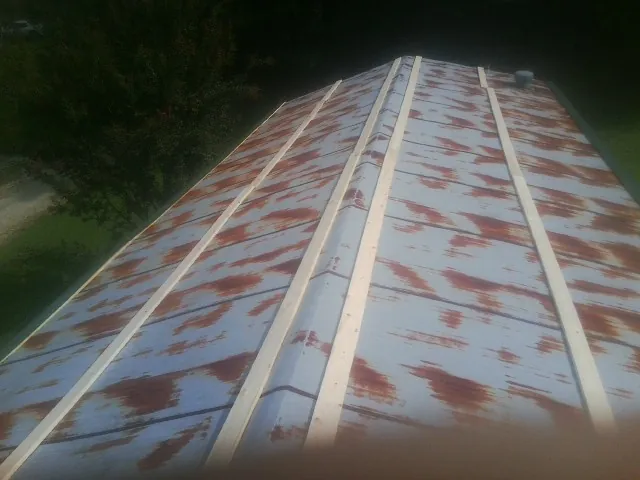 Rusted metal roof panels with new wood purlins before replacement — Storm Damage Roof Repair in Grand View by Roofing Brothers