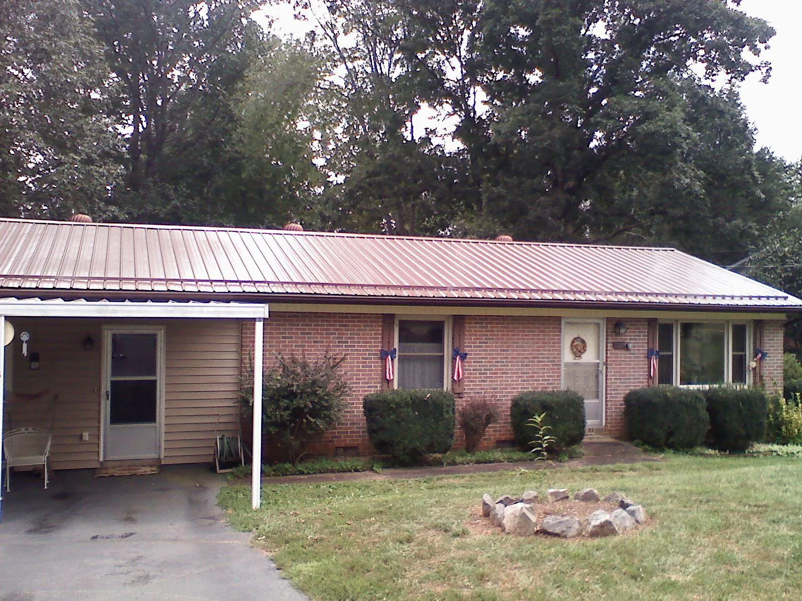 Bronze metal roof and carport on a brick ranch home — Roof Repair work by our crew in Grand View